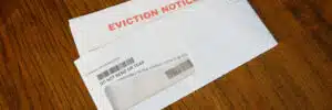 Close-up Of An Eviction Notice In an envelope on a desk, left angled.